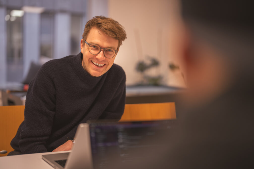 Systemutvecklare som ler på kontoret hos Holly Tech - konsultbolag i Göteborg med gôrgoa systemutvecklare.